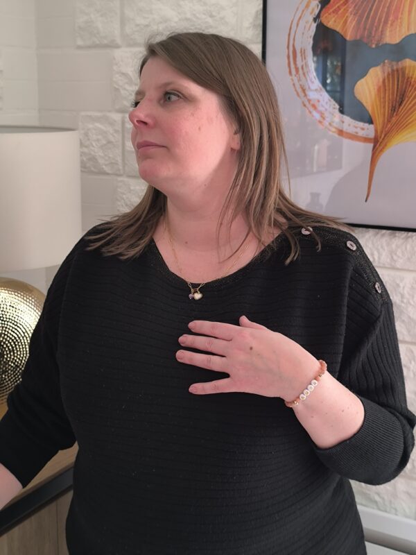 Femme montrant un collier grosse maille en lépidolite et pendentif coeur créé par Main de crystal