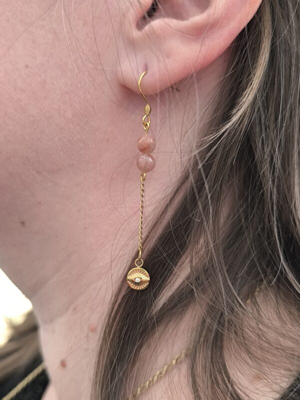 Femme portant les boucles d'oreilles "lumière sacrée", créées par Main de Crystal